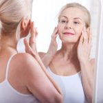 Middle aged woman looking at wrinkles in mirror. Plastic surgery and collagen injections. Makeup. Macro face. Selective focus on the face. Realistic images with their own imperfections.