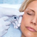 Woman with her eyes closed receiving Botox injection