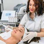 Woman getting ultrasonic and laser face treatment at beauty spa.